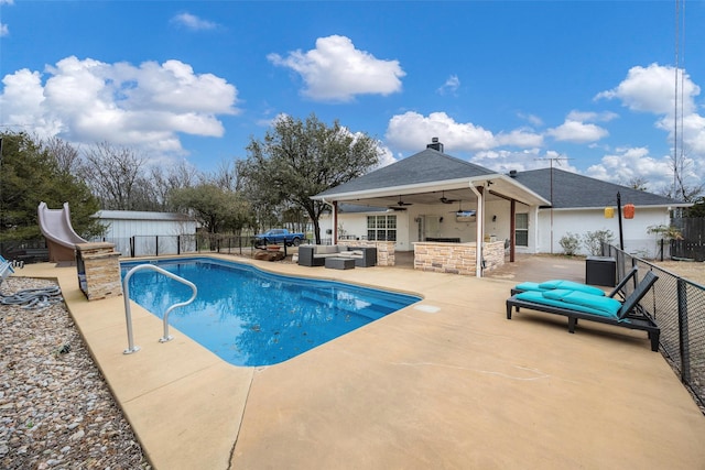 view of swimming pool featuring ceiling fan, a patio, fence, and an outdoor hangout area