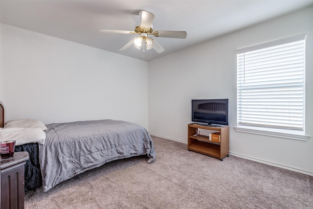 carpeted bedroom featuring baseboards and ceiling fan