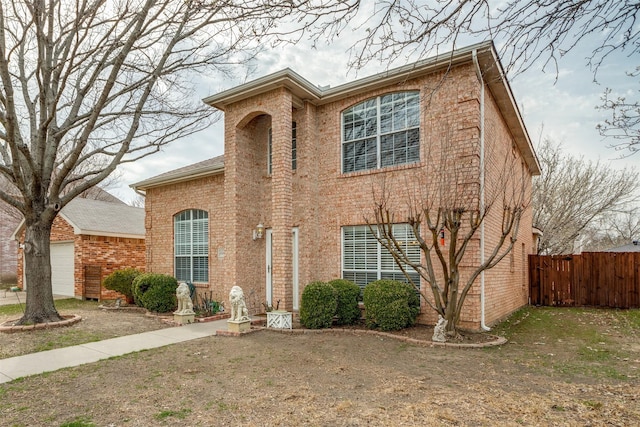 traditional-style home with a garage, fence, and brick siding