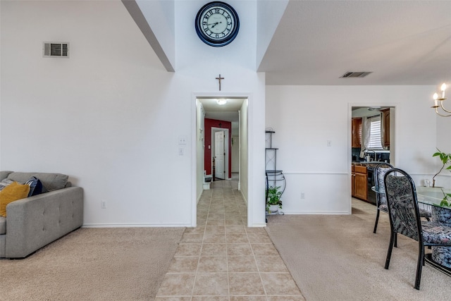 interior space featuring light tile patterned floors, visible vents, and light carpet