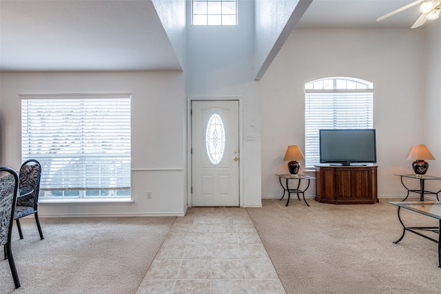 entryway with tile patterned flooring, carpet flooring, plenty of natural light, and ceiling fan