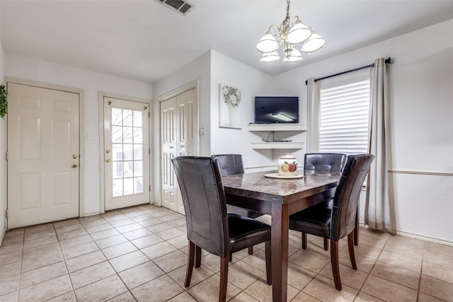 dining room featuring light tile patterned floors, visible vents, plenty of natural light, and an inviting chandelier