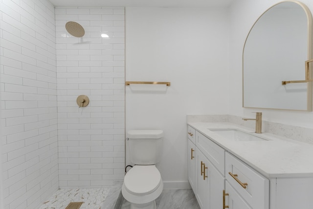 bathroom featuring baseboards, tiled shower, toilet, and vanity