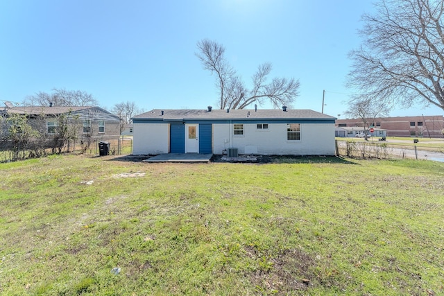 back of property with a yard, central air condition unit, and fence