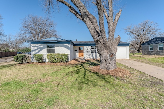 view of front facade with brick siding, concrete driveway, a front lawn, and fence