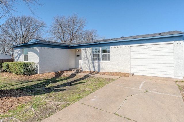 view of front of home featuring concrete driveway and brick siding