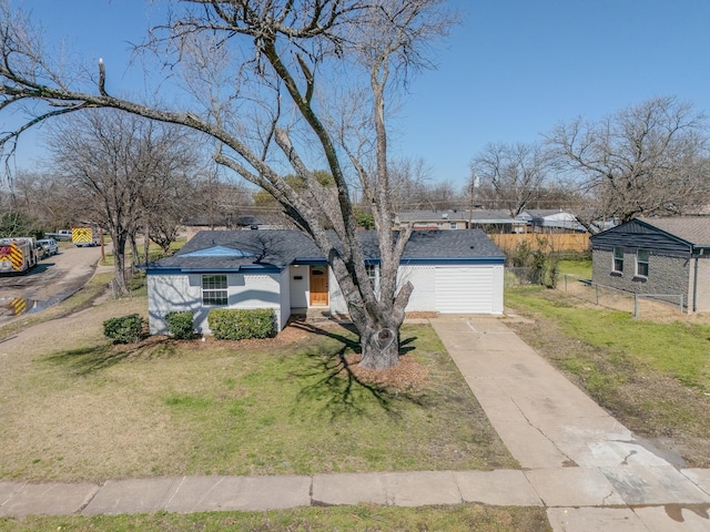 view of front facade featuring concrete driveway, a front lawn, and fence