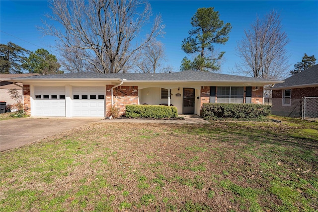 ranch-style home with a front yard, fence, brick siding, and driveway