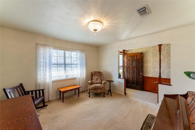 living area with visible vents, carpet floors, and a textured ceiling