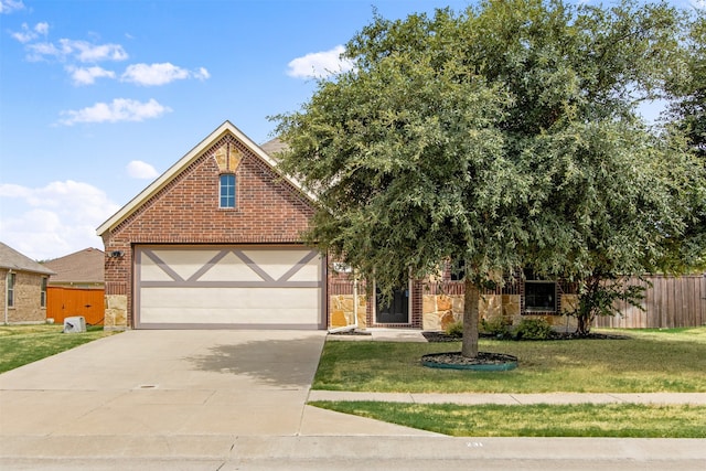 view of front facade featuring brick siding, concrete driveway, a front yard, and fence