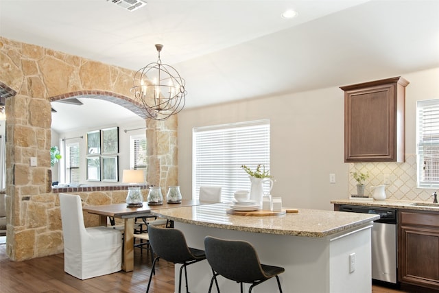 231 Archer Way, Forney, TX 75126 - kitchen with a center island, decorative backsplash, wood finished floors, arched walkways, and stainless steel dishwasher