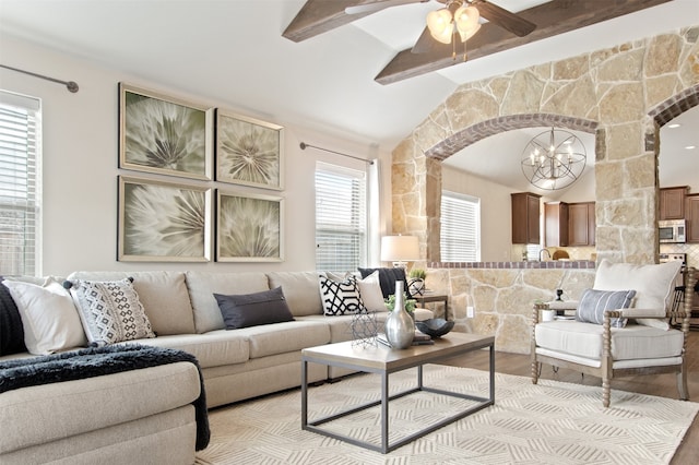 231 Archer Way, Forney, TX 75126 - living room with arched walkways, ceiling fan with notable chandelier, lofted ceiling with beams, and wood finished floors