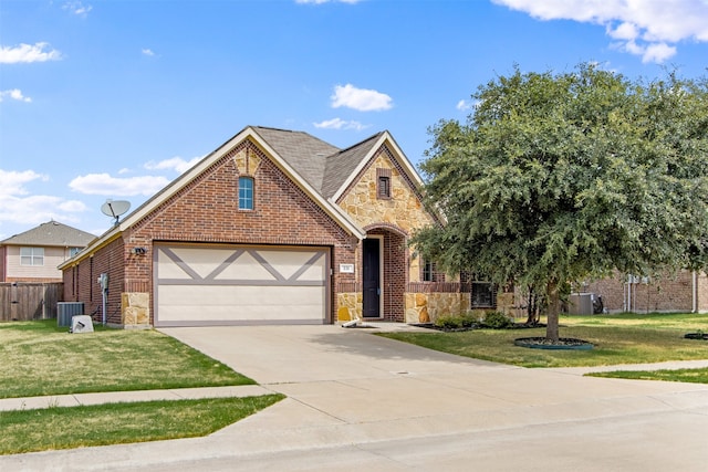 english style home with a front yard, fence, driveway, stone siding, and brick siding