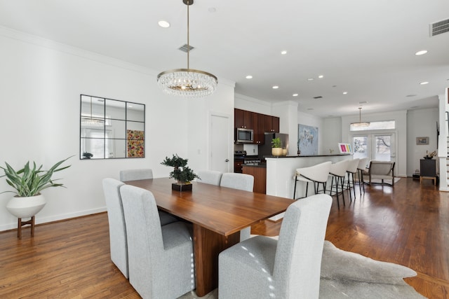 dining area with dark wood finished floors, crown molding, recessed lighting, and visible vents