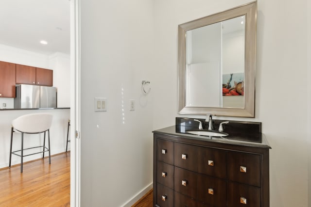 bathroom featuring baseboards, wood finished floors, and vanity