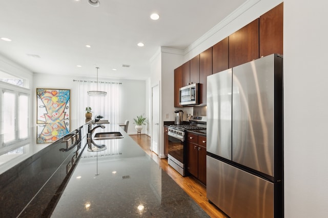 kitchen with a sink, dark stone counters, recessed lighting, and stainless steel appliances