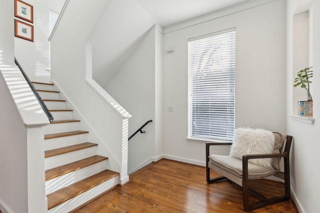 staircase featuring baseboards and wood finished floors