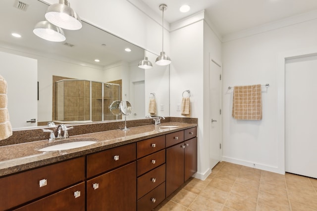 full bathroom featuring visible vents, a shower stall, double vanity, tile patterned floors, and a sink