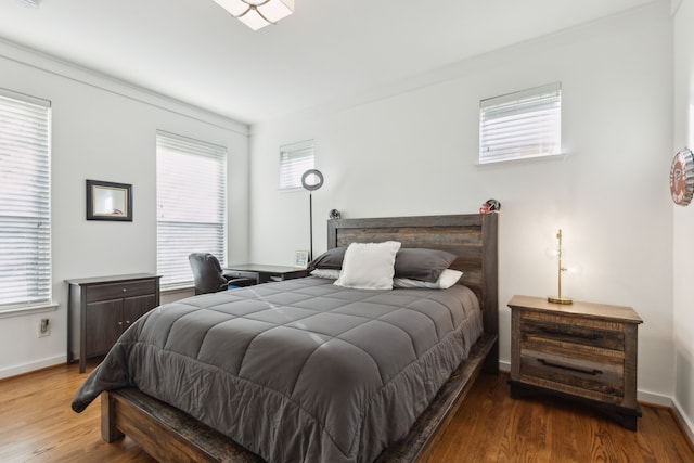 bedroom featuring wood finished floors and baseboards