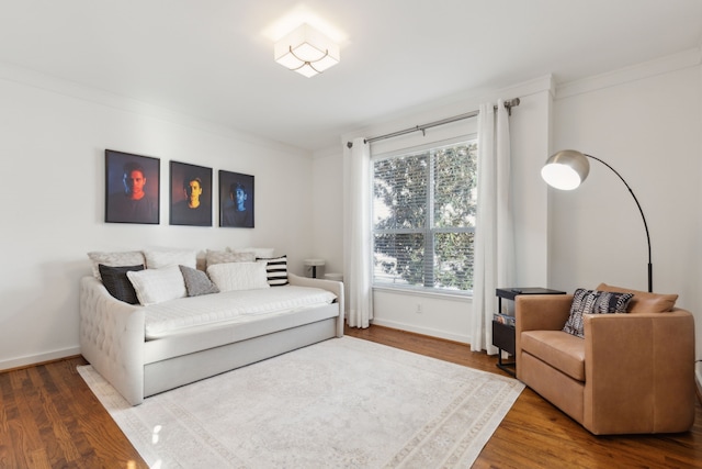 living room featuring baseboards, wood finished floors, and crown molding