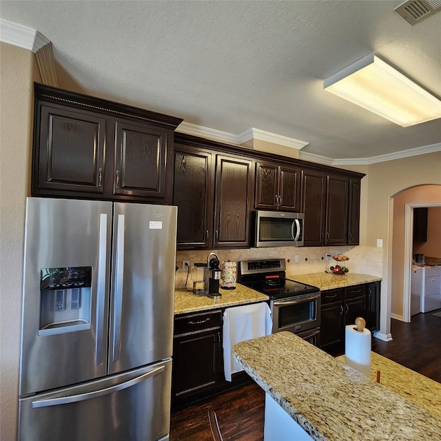 kitchen with arched walkways, visible vents, dark wood finished floors, and stainless steel appliances