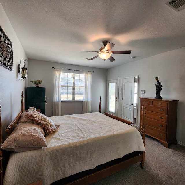 carpeted bedroom featuring visible vents, a textured ceiling, and ceiling fan