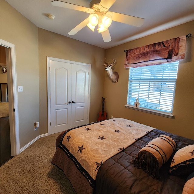 bedroom with a closet, baseboards, a ceiling fan, and carpet