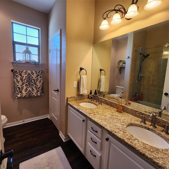 full bath featuring an enclosed shower, toilet, wood finished floors, and a sink