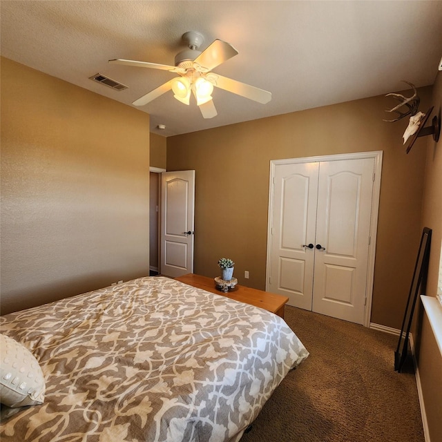 bedroom with a closet, visible vents, dark carpet, and a ceiling fan