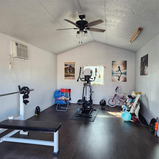 workout area featuring a ceiling fan, wood finished floors, baseboards, vaulted ceiling, and a wall mounted air conditioner