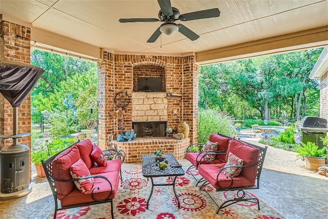 view of patio featuring grilling area, fence, a ceiling fan, and an outdoor living space with a fireplace