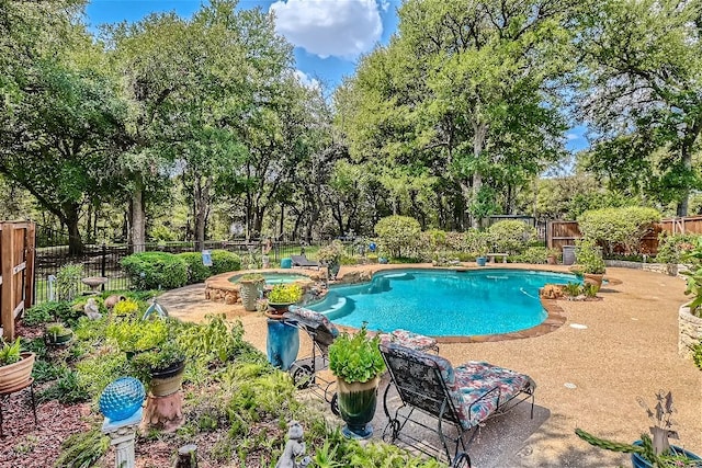 view of pool featuring a patio, a fenced backyard, and a pool with connected hot tub