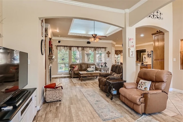 living area with ceiling fan, light wood-style flooring, baseboards, and ornamental molding