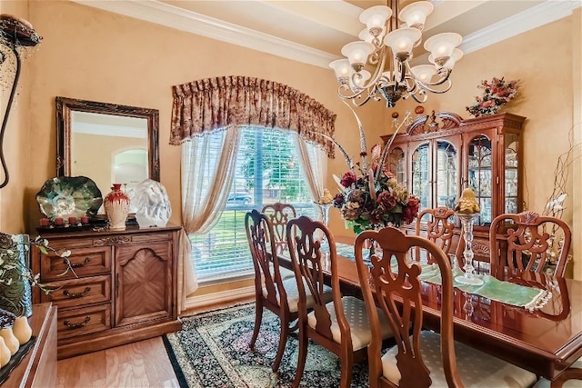 dining space with crown molding, light wood-style floors, and a chandelier