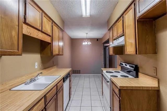 6743 Westcreek Dr, Fort Worth, TX 76133 - kitchen with visible vents, white dishwasher, a sink, electric stove, and under cabinet range hood