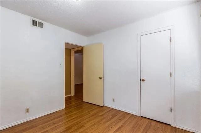 6743 Westcreek Dr, Fort Worth, TX 76133 - spare room featuring light wood-style floors, visible vents, and baseboards
