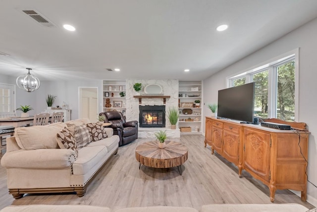 living area with visible vents, built in features, recessed lighting, light wood-style flooring, and an inviting chandelier