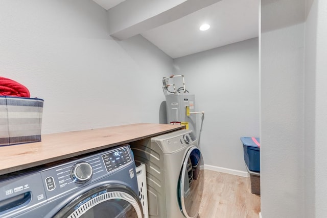 laundry room featuring baseboards, laundry area, light wood-style floors, electric water heater, and independent washer and dryer