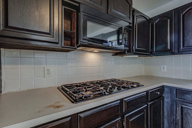 kitchen with decorative backsplash, black appliances, and light countertops