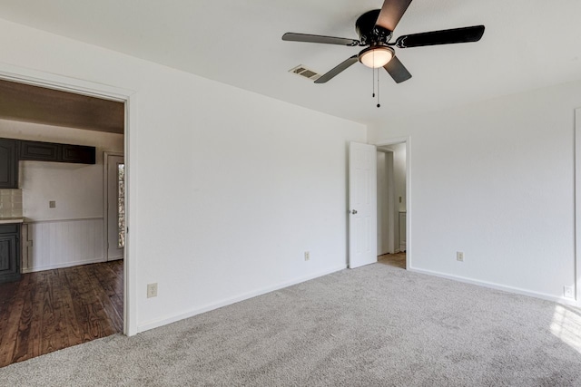 carpeted empty room with visible vents and ceiling fan