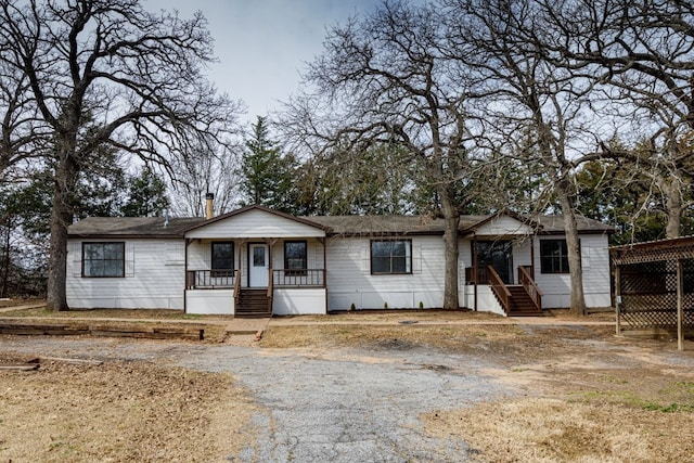 ranch-style house featuring a porch and driveway