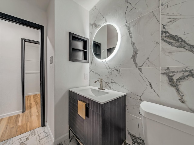 bathroom with vanity, toilet, and marble finish floor