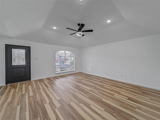 unfurnished living room with lofted ceiling, a ceiling fan, recessed lighting, light wood-style floors, and baseboards