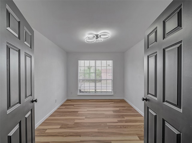 unfurnished room with light wood-style flooring and baseboards