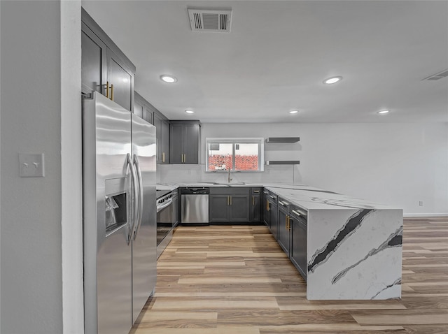 kitchen with light wood finished floors, visible vents, appliances with stainless steel finishes, and a sink