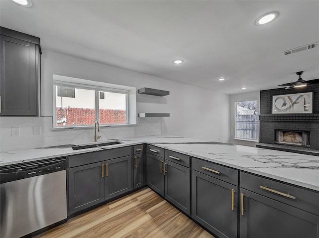 kitchen featuring visible vents, plenty of natural light, dishwasher, and a fireplace