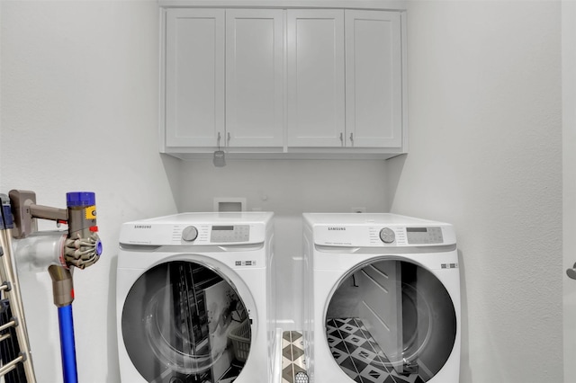 clothes washing area with cabinet space and washing machine and clothes dryer