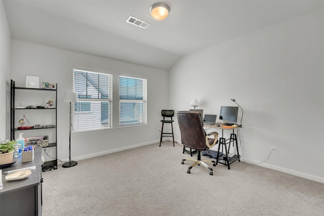 carpeted office featuring lofted ceiling, baseboards, and visible vents