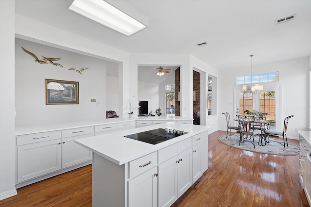 kitchen with visible vents, light countertops, black electric stovetop, and wood finished floors