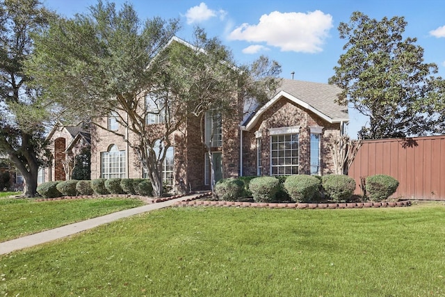 view of front of house with a front yard and brick siding